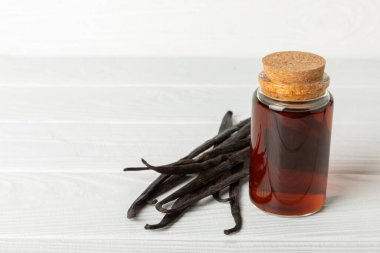 Tahta bir masanın üzerinde cam kaplama vanilya özü. Kek ve tatlı için vanilya özü. Aromatik ev yapımı vanilya özü. Kapatın. Mesajı yerleştir. Boşluğu kopyala.