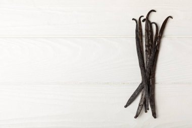 Dokulu bir arka planda vanilya kabukları. Vanilya çiçekleri ve tohumlar. Vanilyalı fasulye. Hamur işleri ve tatlılar için baharatlı baharat. Baharat. Mesaj için yer var. Boşluğu Kopyala