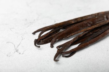 Dokulu bir arka planda vanilya kabukları. Vanilya çiçekleri ve tohumlar. Vanilyalı fasulye. Hamur işleri ve tatlılar için baharatlı baharat. Baharat. Mesaj için yer var. Boşluğu Kopyala