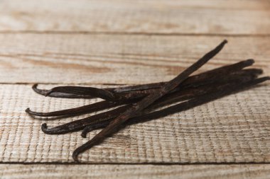 Dokulu bir arka planda vanilya kabukları. Vanilya çiçekleri ve tohumlar. Vanilyalı fasulye. Hamur işleri ve tatlılar için baharatlı baharat. Baharat. Mesaj için yer var. Boşluğu Kopyala