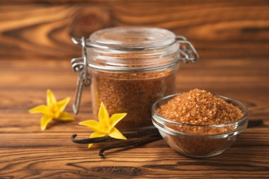 Aromatik vanilya şekeri. Vanilya kabukları. Vanilya çubukları, esmer ve beyaz şeker dokulu arka planda bir kasede. Vanilya çiçekleri, baharatlar ve tatlı ve pişirme için bitkiler. Mesaj için yer var. Boşluğu kopyala