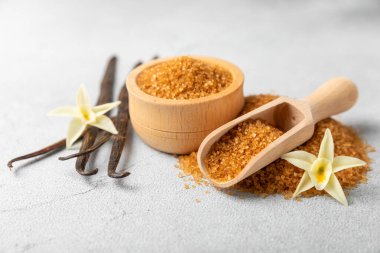 Aromatik vanilya şekeri. Vanilya kabukları. Vanilya çubukları, esmer ve beyaz şeker dokulu arka planda bir kasede. Vanilya çiçekleri, baharatlar ve tatlı ve pişirme için bitkiler. Mesaj için yer var. Boşluğu kopyala