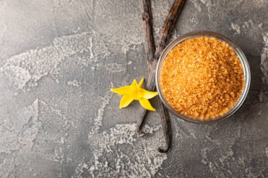 Aromatik vanilya şekeri. Vanilya kabukları. Vanilya çubukları, esmer ve beyaz şeker dokulu arka planda bir kasede. Vanilya çiçekleri, baharatlar ve tatlı ve pişirme için bitkiler. Mesaj için yer var. Boşluğu kopyala