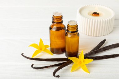 Bir şişe vanilya yağı ve desenli arka planda vanilya çiçeği. aromatik vanilyalı fasulye. Vanilya özü. Spa konsepti. Güzellik ve özen. Mesaj için yer. Boşluğu kopyala.