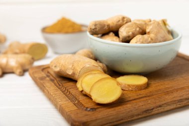 Ahşap arka planda taze zencefil. Kuru zencefil. Ballı ve limonlu zencefil dilimi. Zencefil kökü. Geleneksel alternatif tıp, bağışıklık için çay. Baharat ve baharat konsepti. Boşluğu kopyala.