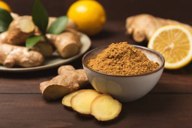 Ahşap arka planda taze zencefil. Kuru zencefil. Ballı ve limonlu zencefil dilimi. Zencefil kökü. Geleneksel alternatif tıp, bağışıklık için çay. Baharat ve baharat konsepti. Boşluğu kopyala.