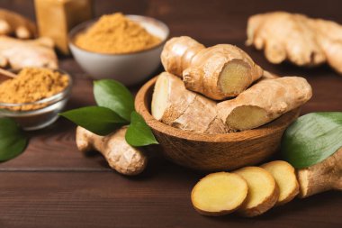 Ahşap arka planda taze zencefil. Kuru zencefil. Ballı ve limonlu zencefil dilimi. Zencefil kökü. Geleneksel alternatif tıp, bağışıklık için çay. Baharat ve baharat konsepti. Boşluğu kopyala.