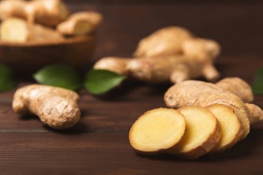 Ahşap arka planda taze zencefil. Kuru zencefil. Ballı ve limonlu zencefil dilimi. Zencefil kökü. Geleneksel alternatif tıp, bağışıklık için çay. Baharat ve baharat konsepti. Boşluğu kopyala.