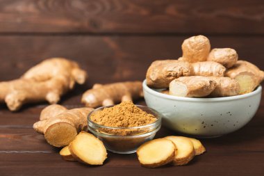 Ahşap arka planda taze zencefil. Kuru zencefil. Ballı ve limonlu zencefil dilimi. Zencefil kökü. Geleneksel alternatif tıp, bağışıklık için çay. Baharat ve baharat konsepti. Boşluğu kopyala.