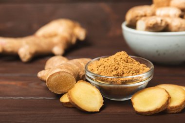 Ahşap arka planda taze zencefil. Kuru zencefil. Ballı ve limonlu zencefil dilimi. Zencefil kökü. Geleneksel alternatif tıp, bağışıklık için çay. Baharat ve baharat konsepti. Boşluğu kopyala.