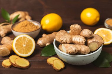 Ahşap arka planda taze zencefil. Kuru zencefil. Ballı ve limonlu zencefil dilimi. Zencefil kökü. Geleneksel alternatif tıp, bağışıklık için çay. Baharat ve baharat konsepti. Boşluğu kopyala.