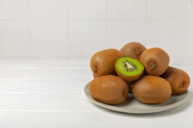 Ahşap arka planda Kivi. Masada tam meyve ve dilimler halinde yeşil kivi var. Taze sulu kivi. Tropik meyve. Organik meyve. Sağlıklı beslenme. Mesaj için yer var. Boşluğu kopyala