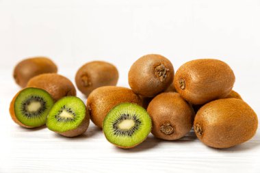 Ahşap arka planda Kivi. Masada tam meyve ve dilimler halinde yeşil kivi var. Taze sulu kivi. Tropik meyve. Organik meyve. Sağlıklı beslenme. Mesaj için yer var. Boşluğu kopyala