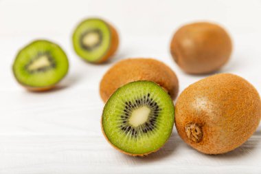 Ahşap arka planda Kivi. Masada tam meyve ve dilimler halinde yeşil kivi var. Taze sulu kivi. Tropik meyve. Organik meyve. Sağlıklı beslenme. Mesaj için yer var. Boşluğu kopyala