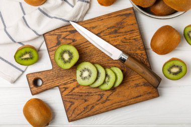 Ahşap arka planda Kivi. Masada tam meyve ve dilimler halinde yeşil kivi var. Taze sulu kivi. Tropik meyve. Organik meyve. Sağlıklı beslenme. Mesaj için yer var. Boşluğu kopyala