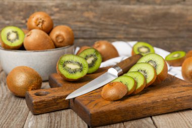 Ahşap arka planda Kivi. Masada tam meyve ve dilimler halinde yeşil kivi var. Taze sulu kivi. Tropik meyve. Organik meyve. Sağlıklı beslenme. Mesaj için yer var. Boşluğu kopyala