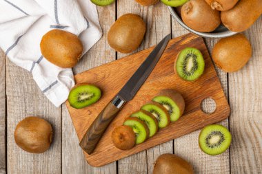 Ahşap arka planda Kivi. Masada tam meyve ve dilimler halinde yeşil kivi var. Taze sulu kivi. Tropik meyve. Organik meyve. Sağlıklı beslenme. Mesaj için yer var. Boşluğu kopyala