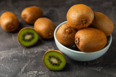 Ahşap arka planda Kivi. Masada tam meyve ve dilimler halinde yeşil kivi var. Taze sulu kivi. Tropik meyve. Organik meyve. Sağlıklı beslenme. Mesaj için yer var. Boşluğu kopyala