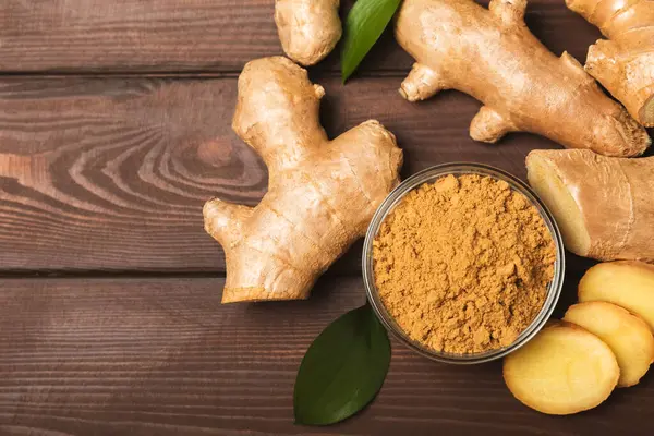Ahşap arka planda taze zencefil. Kuru zencefil. Ballı ve limonlu zencefil dilimi. Zencefil kökü. Geleneksel alternatif tıp, bağışıklık için çay. Baharat ve baharat konsepti. Boşluğu kopyala.