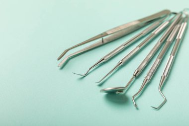 Mavi arkaplandaki dişçi aletleri. Diş hekimi konsepti. Diş bakımı, diş sağlığı konsepti. Ağız boşluğuna dikkat etmek anlamına geliyor. Diş modeli ve dişçi aletleri. Diş hijyeni. Mesaj için yer var. Boşluğu kopyala.
