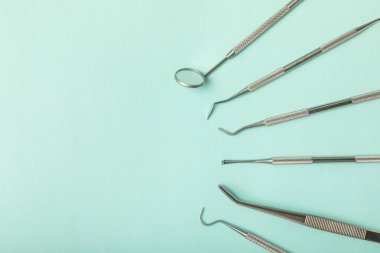 Mavi arkaplandaki dişçi aletleri. Diş hekimi konsepti. Diş bakımı, diş sağlığı konsepti. Ağız boşluğuna dikkat etmek anlamına geliyor. Diş modeli ve dişçi aletleri. Diş hijyeni. Mesaj için yer var. Boşluğu kopyala.