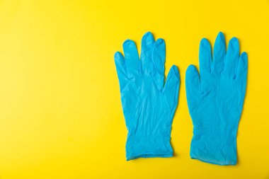 Tıbbi nitril eldivenler, mavi başlık, desenli arka planda tek kullanımlık tıbbi maske. Tıbbi koruyucu giysi. Cerrahi lateks eldivenler. Lastik eldiven üretimi. Tıp konsepti. Üst Manzara. Metni kopyala