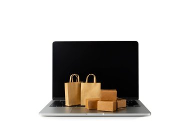 Çevrimiçi alışveriş kavramı. Karton kutu ve alışveriş poşetleri beyaz arka planda izole edilmiş bir tramvayda. Alışveriş sepeti. İnternetten bilgisayar, tablet, telefon ve kredi kartı kullanarak alışveriş. Eve teslim.