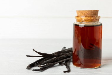 Tahta bir masanın üzerinde cam kaplama vanilya özü. Kek ve tatlı için vanilya özü. Aromatik ev yapımı vanilya özü. Kapatın. Mesajı yerleştir. Boşluğu kopyala.