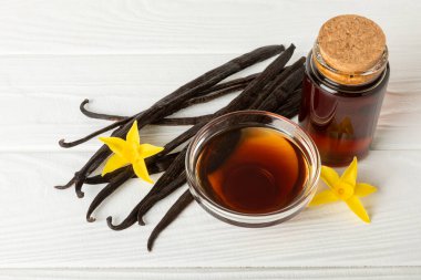 Tahta bir masanın üzerinde cam kaplama vanilya özü. Kek ve tatlı için vanilya özü. Aromatik ev yapımı vanilya özü. Kapatın. Mesajı yerleştir. Boşluğu kopyala.