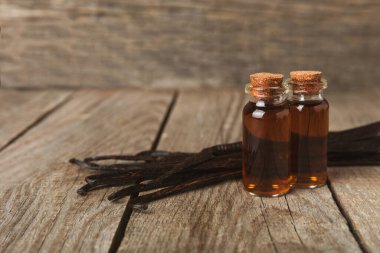 Tahta bir masanın üzerinde cam kaplama vanilya özü. Kek ve tatlı için vanilya özü. Aromatik ev yapımı vanilya özü. Kapatın. Mesajı yerleştir. Boşluğu kopyala.