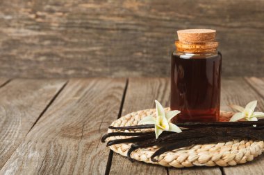 Tahta bir masanın üzerinde cam kaplama vanilya özü. Kek ve tatlı için vanilya özü. Aromatik ev yapımı vanilya özü. Kapatın. Mesajı yerleştir. Boşluğu kopyala.