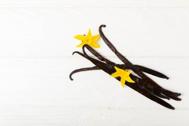 Dokulu bir arka planda vanilya kabukları. Vanilya çiçekleri ve tohumlar. Vanilyalı fasulye. Hamur işleri ve tatlılar için baharatlı baharat. Baharat. Mesaj için yer var. Boşluğu Kopyala