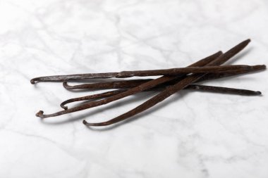 Dokulu bir arka planda vanilya kabukları. Vanilya çiçekleri ve tohumlar. Vanilyalı fasulye. Hamur işleri ve tatlılar için baharatlı baharat. Baharat. Mesaj için yer var. Boşluğu Kopyala