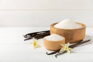 Aromatik vanilya şekeri. Vanilya kabukları. Vanilya çubukları, esmer ve beyaz şeker dokulu arka planda bir kasede. Vanilya çiçekleri, baharatlar ve tatlı ve pişirme için bitkiler. Mesaj için yer var. Boşluğu kopyala