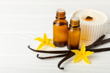 Bir şişe vanilya yağı ve desenli arka planda vanilya çiçeği. aromatik vanilyalı fasulye. Vanilya özü. Spa konsepti. Güzellik ve özen. Mesaj için yer. Boşluğu kopyala.