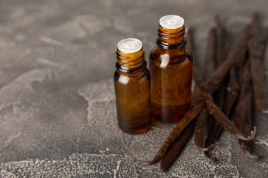 Bir şişe vanilya yağı ve desenli arka planda vanilya çiçeği. aromatik vanilyalı fasulye. Vanilya özü. Spa konsepti. Güzellik ve özen. Mesaj için yer. Boşluğu kopyala.