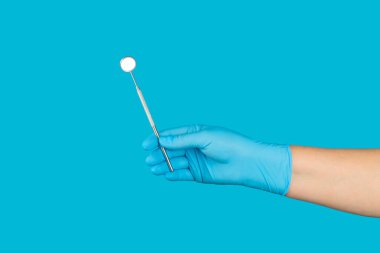 Diş hekimiyle çalışan bir dişçi ve mavi arka planda sağlıklı beyaz diş modeli. Diş bakımı, diş tedavisi, diş çektirme, implantasyon konsepti. Diş hijyeni. Boşluğu kopyala