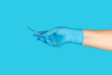 Diş hekimiyle çalışan bir dişçi ve mavi arka planda sağlıklı beyaz diş modeli. Diş bakımı, diş tedavisi, diş çektirme, implantasyon konsepti. Diş hijyeni. Boşluğu kopyala