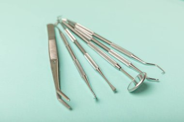 Mavi arkaplandaki dişçi aletleri. Diş hekimi konsepti. Diş bakımı, diş sağlığı konsepti. Ağız boşluğuna dikkat etmek anlamına geliyor. Diş modeli ve dişçi aletleri. Diş hijyeni. Mesaj için yer var. Boşluğu kopyala.
