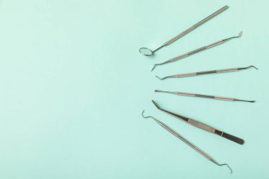 Mavi arkaplandaki dişçi aletleri. Diş hekimi konsepti. Diş bakımı, diş sağlığı konsepti. Ağız boşluğuna dikkat etmek anlamına geliyor. Diş modeli ve dişçi aletleri. Diş hijyeni. Mesaj için yer var. Boşluğu kopyala.