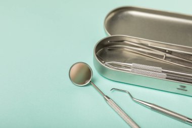 Mavi arkaplandaki dişçi aletleri. Diş hekimi konsepti. Diş bakımı, diş sağlığı konsepti. Ağız boşluğuna dikkat etmek anlamına geliyor. Diş modeli ve dişçi aletleri. Diş hijyeni. Mesaj için yer var. Boşluğu kopyala.
