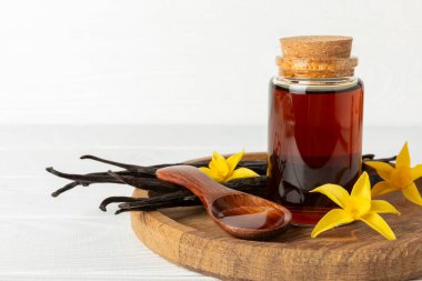 Tahta bir masanın üzerinde cam kaplama vanilya özü. Kek ve tatlı için vanilya özü. Aromatik ev yapımı vanilya özü. Kapatın. Mesajı yerleştir. Boşluğu kopyala.