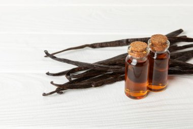 Tahta bir masanın üzerinde cam kaplama vanilya özü. Kek ve tatlı için vanilya özü. Aromatik ev yapımı vanilya özü. Kapatın. Mesajı yerleştir. Boşluğu kopyala.