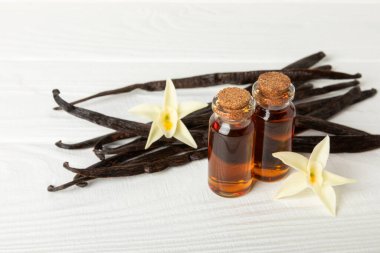 Tahta bir masanın üzerinde cam kaplama vanilya özü. Kek ve tatlı için vanilya özü. Aromatik ev yapımı vanilya özü. Kapatın. Mesajı yerleştir. Boşluğu kopyala.