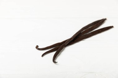 Dokulu bir arka planda vanilya kabukları. Vanilya çiçekleri ve tohumlar. Vanilyalı fasulye. Hamur işleri ve tatlılar için baharatlı baharat. Baharat. Mesaj için yer var. Boşluğu Kopyala