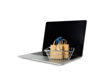 Çevrimiçi alışveriş kavramı. Karton kutu ve alışveriş poşetleri beyaz arka planda izole edilmiş bir tramvayda. Alışveriş sepeti. İnternetten bilgisayar, tablet, telefon ve kredi kartı kullanarak alışveriş. Eve teslim.