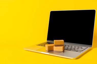 Çevrimiçi alışveriş kavramı. Karton kutu ve parlak renkli bir arka planda tramvayda alışveriş poşetleri. Alışveriş sepeti. İnternetten bilgisayar, tablet, telefon ve kredi kartı kullanarak alışveriş. Eve teslim.