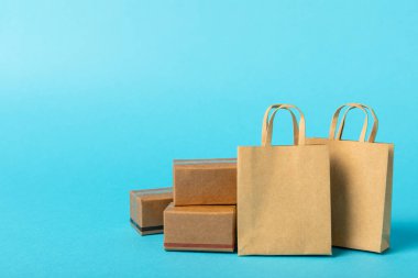 Çevrimiçi alışveriş kavramı. Karton kutu ve parlak renkli bir arka planda tramvayda alışveriş poşetleri. Alışveriş sepeti. İnternetten bilgisayar, tablet, telefon ve kredi kartı kullanarak alışveriş. Eve teslim.