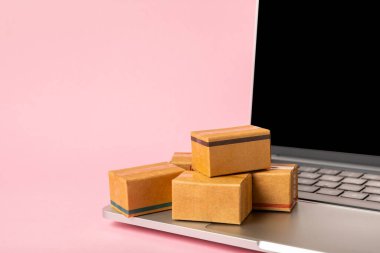 Çevrimiçi alışveriş kavramı. Karton kutu ve parlak renkli bir arka planda tramvayda alışveriş poşetleri. Alışveriş sepeti. İnternetten bilgisayar, tablet, telefon ve kredi kartı kullanarak alışveriş. Eve teslim.