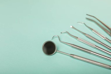 Mavi arkaplandaki dişçi aletleri. Diş hekimi konsepti. Diş bakımı, diş sağlığı konsepti. Ağız boşluğuna dikkat etmek anlamına geliyor. Diş modeli ve dişçi aletleri. Diş hijyeni. Mesaj için yer var. Boşluğu kopyala.